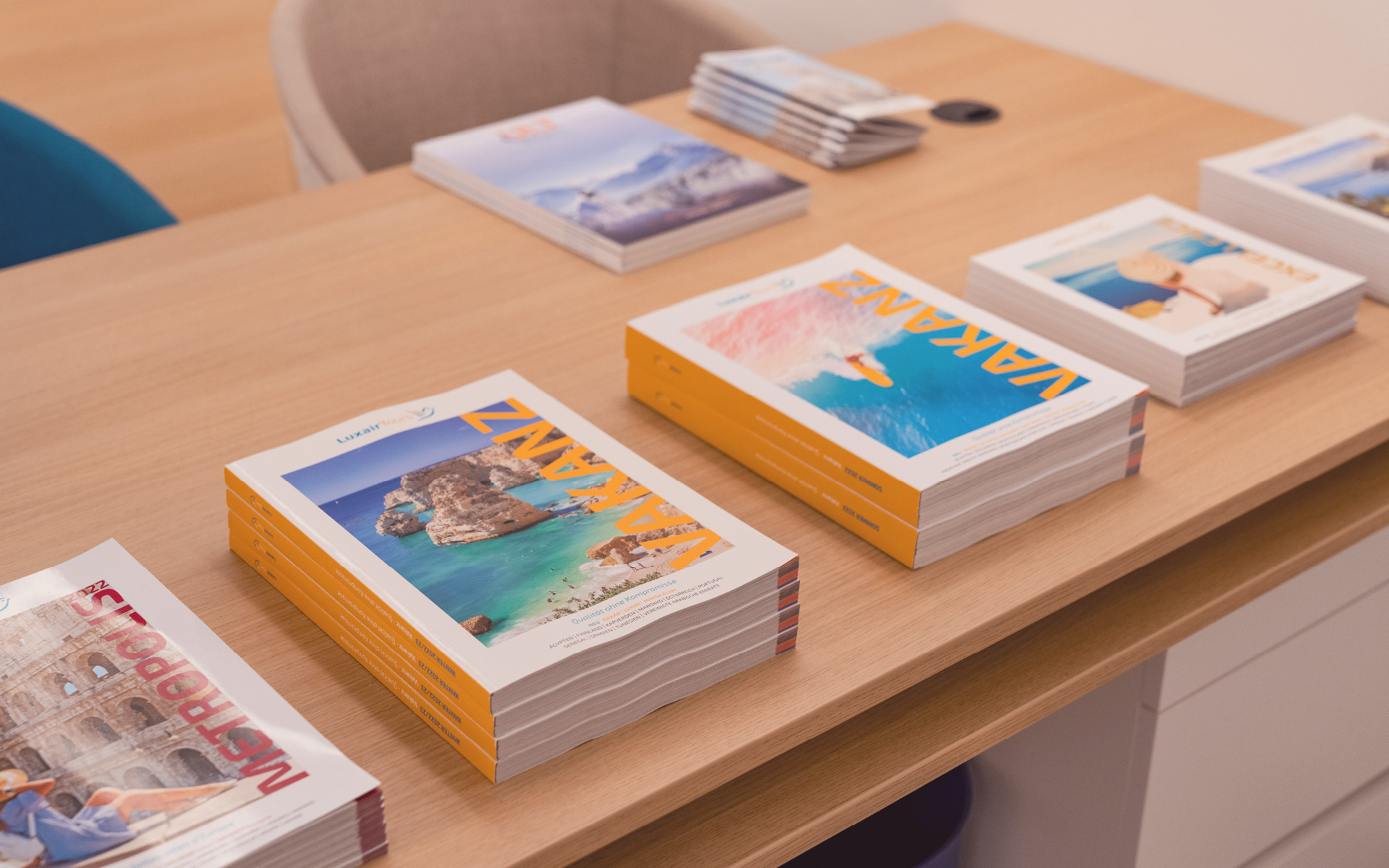 Des catalogues de voyage se trouvent sur la table